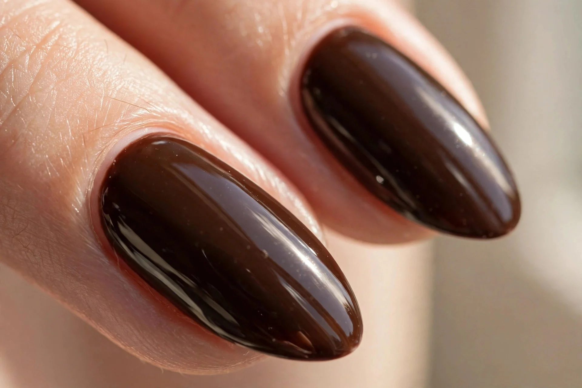 Medium almond nails in deep espresso-brown polish with high gloss.