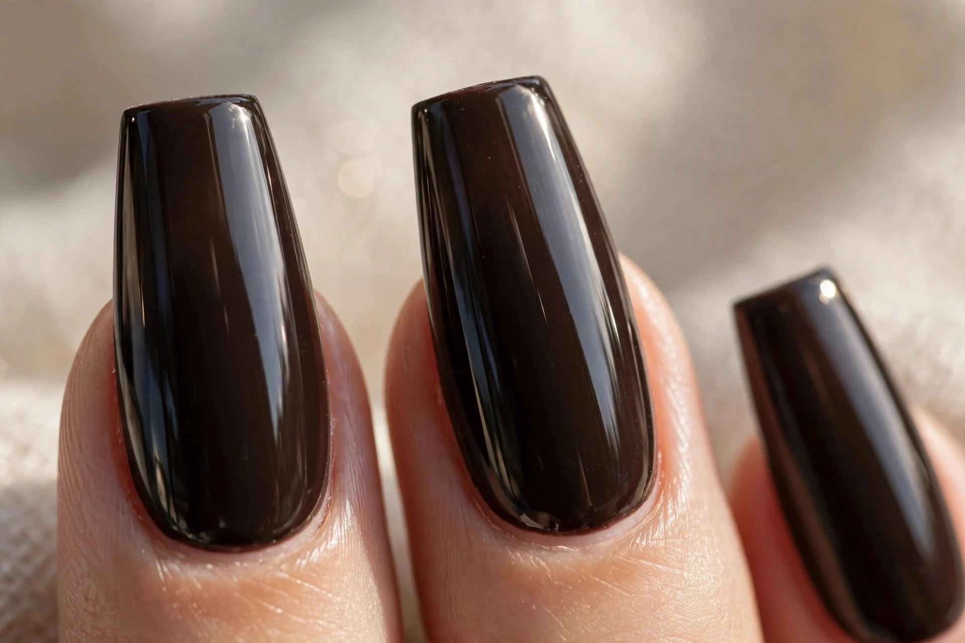 Long coffin nails in near-black brown polish with a mirror-gloss finish.