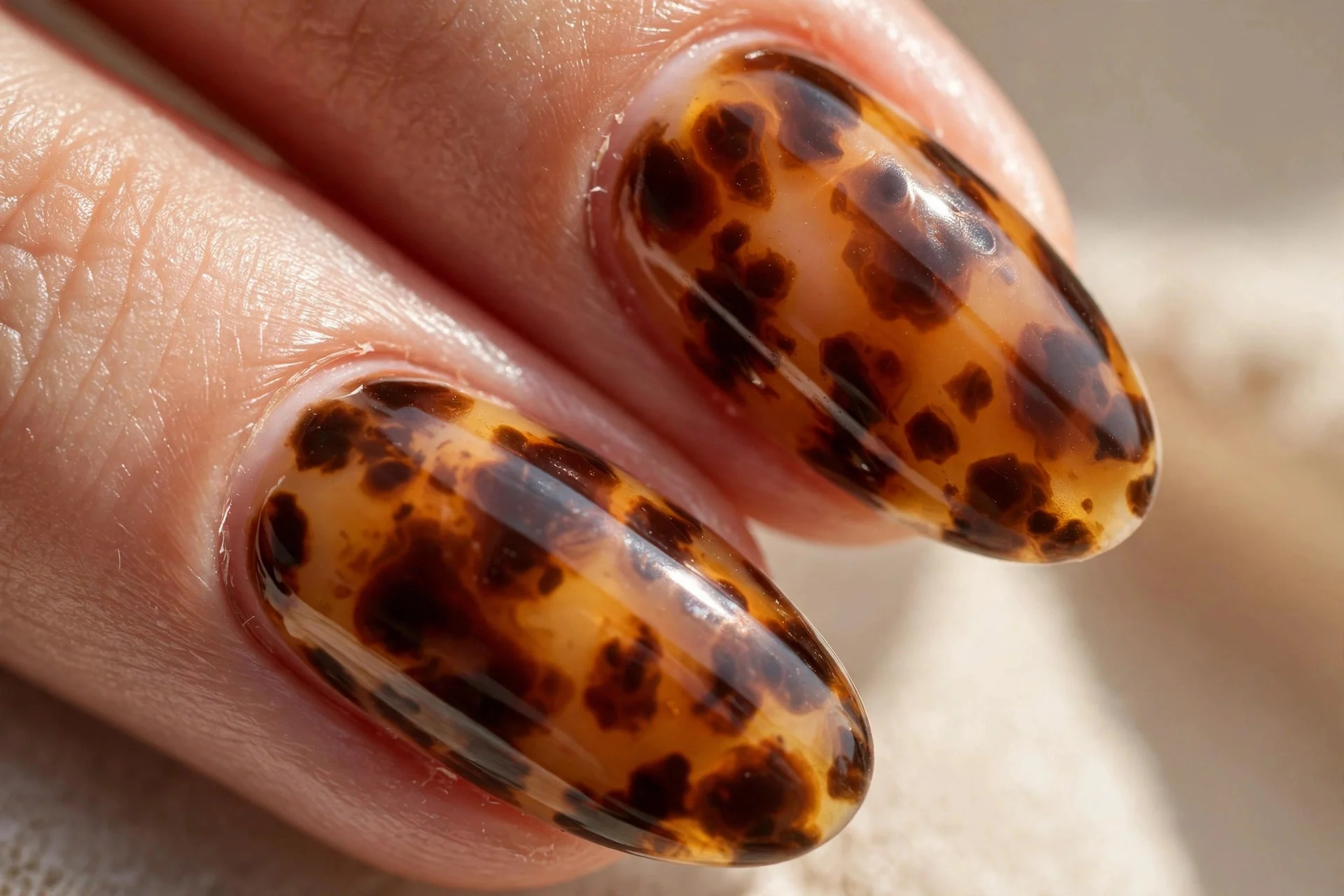 Almond nails with a tortoise-shell pattern in caramel and chocolate brown.