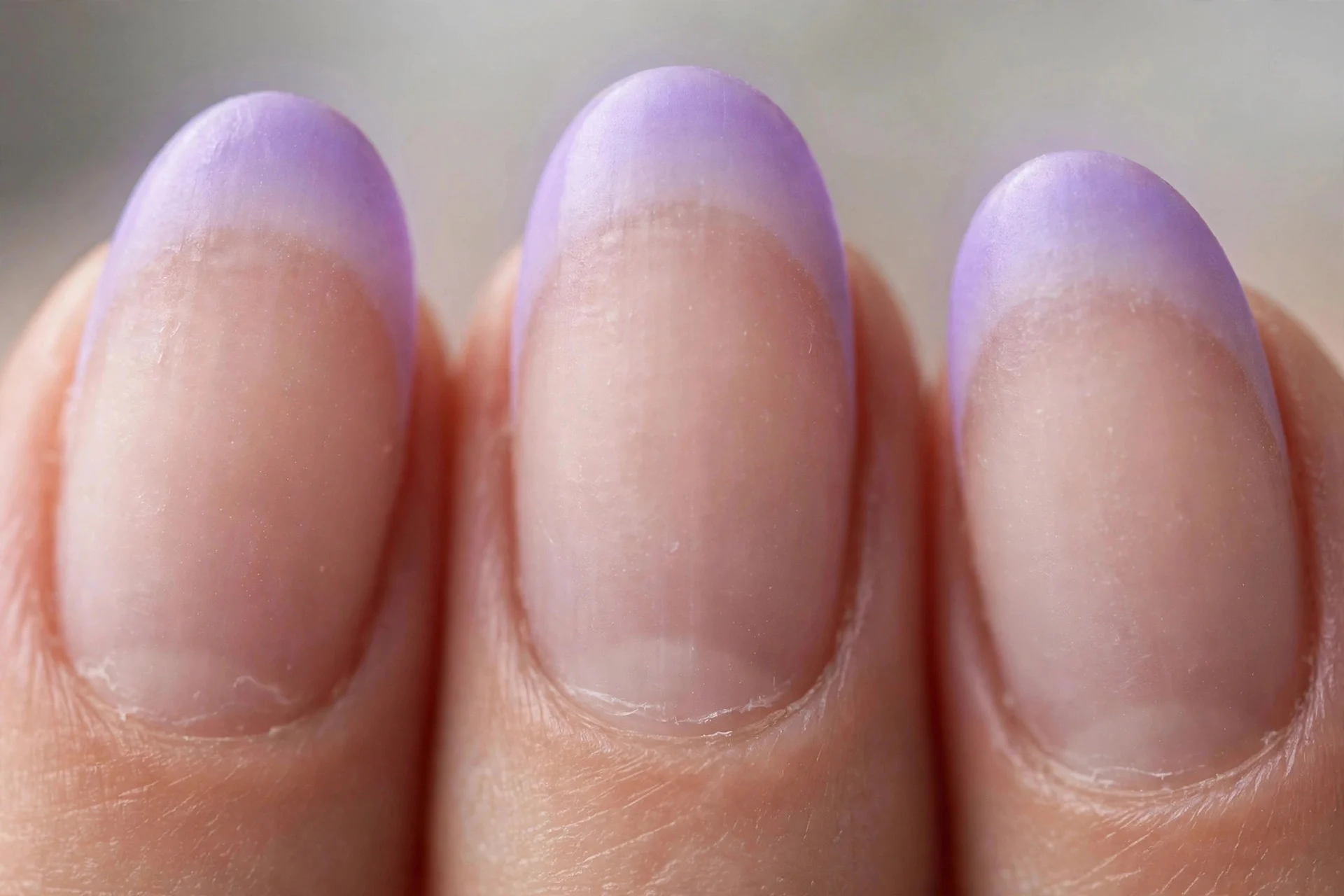 Sheer nude nails with lavender aura French tips, short oval nails