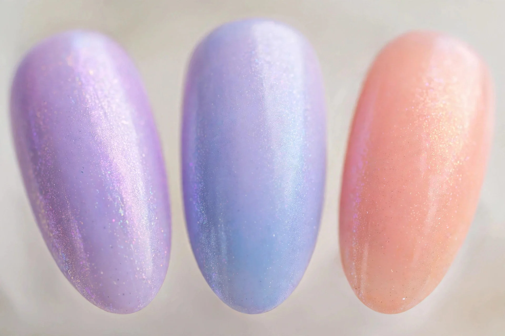 Pastel rainbow aura nails from lavender to lilac blue and peach, medium almond
