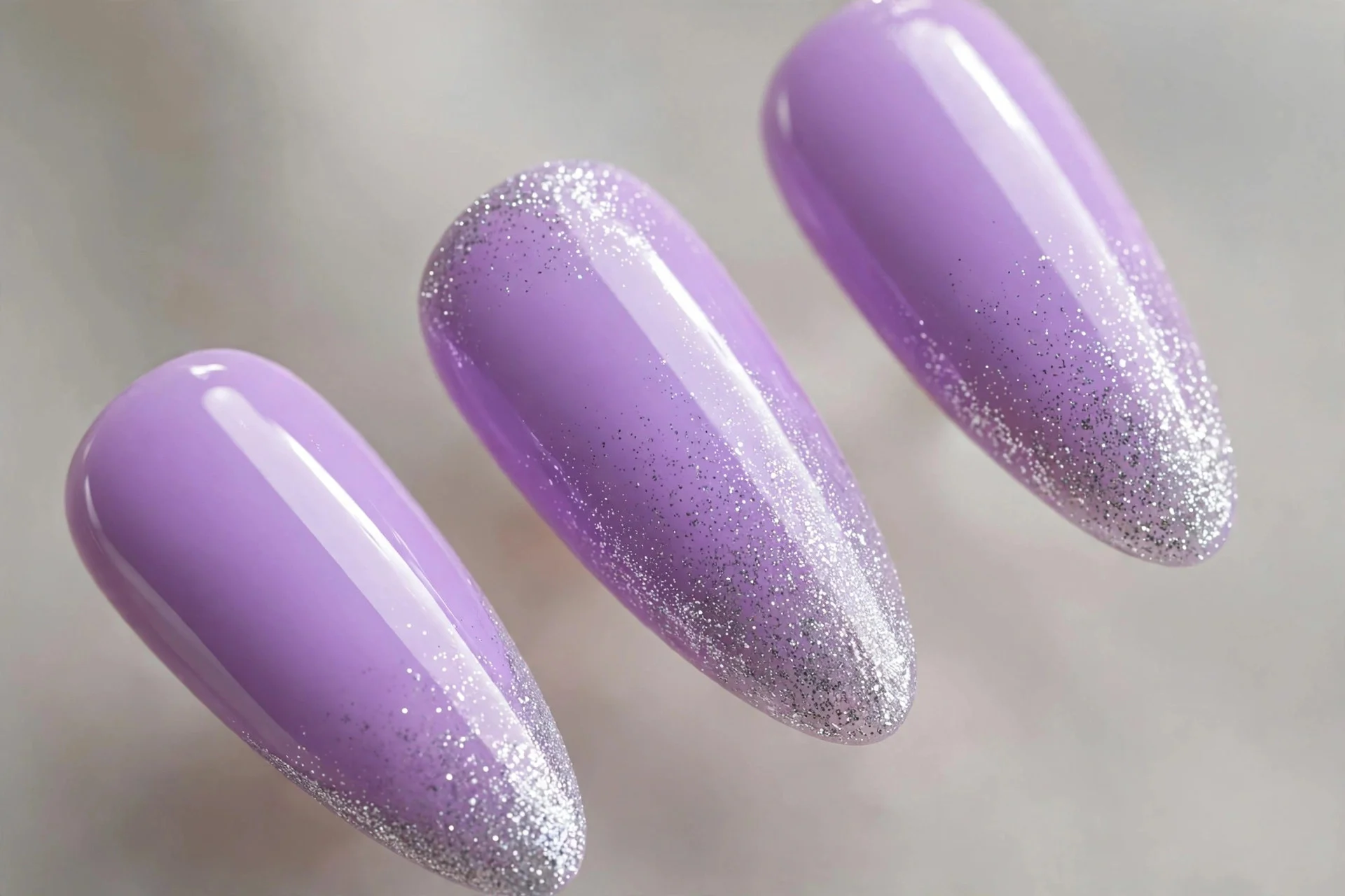 Bright lilac nails with silver glitter fade tips, long almond