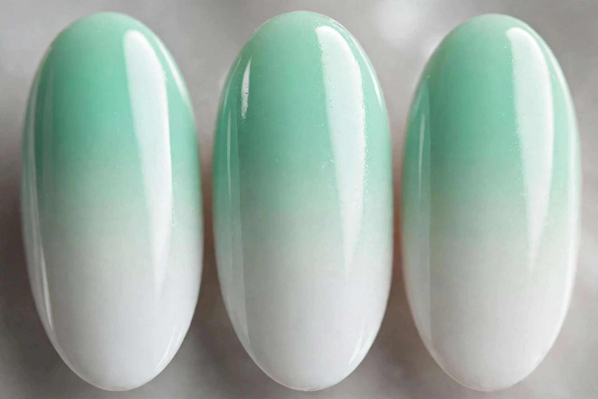 Mint to white sponged ombré gradient, medium almond nails
