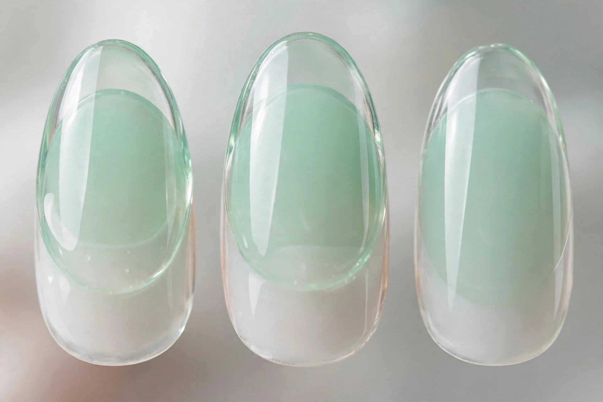 Sheer mint jelly nails over milky white base, almond