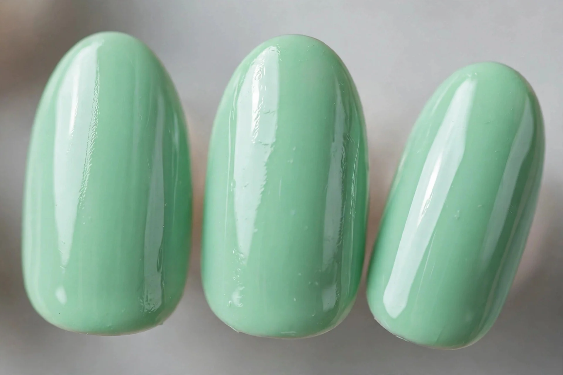 Mint green press-on nails, short almond shape, glossy