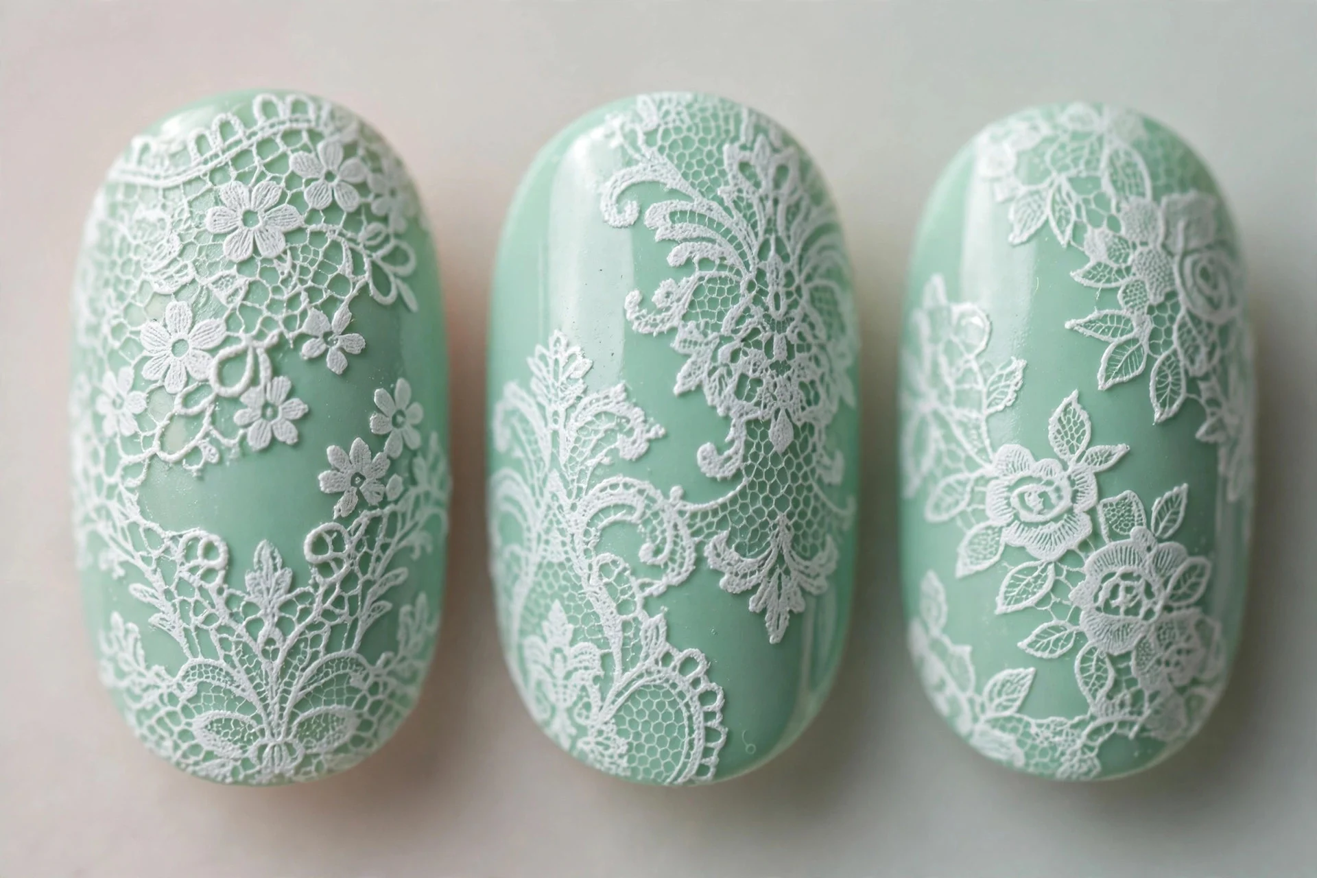 Mint nails with stamped white lace pattern, oval