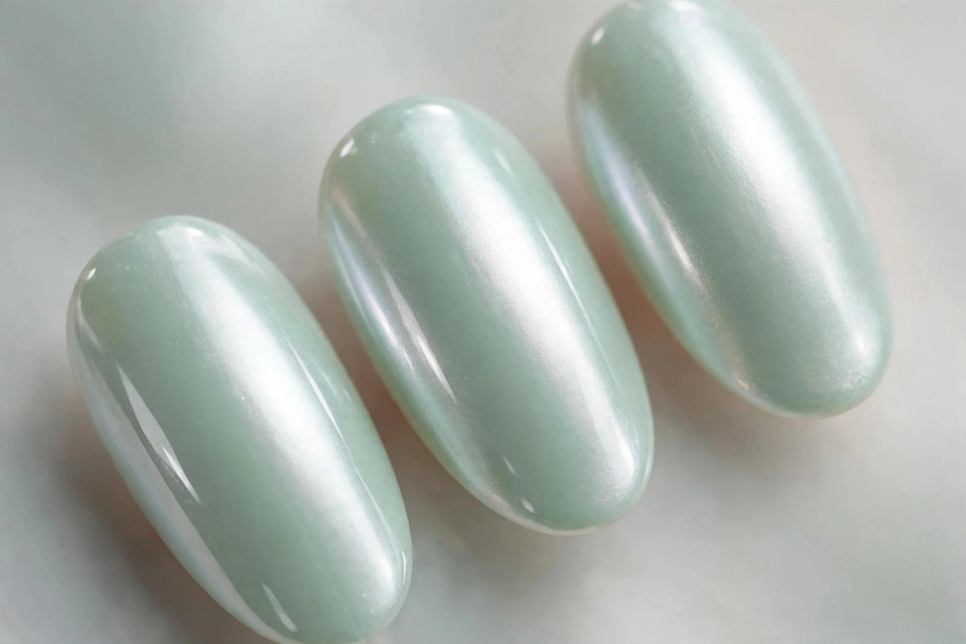 Mint polish with pearl chrome finish, almond nails, luminous