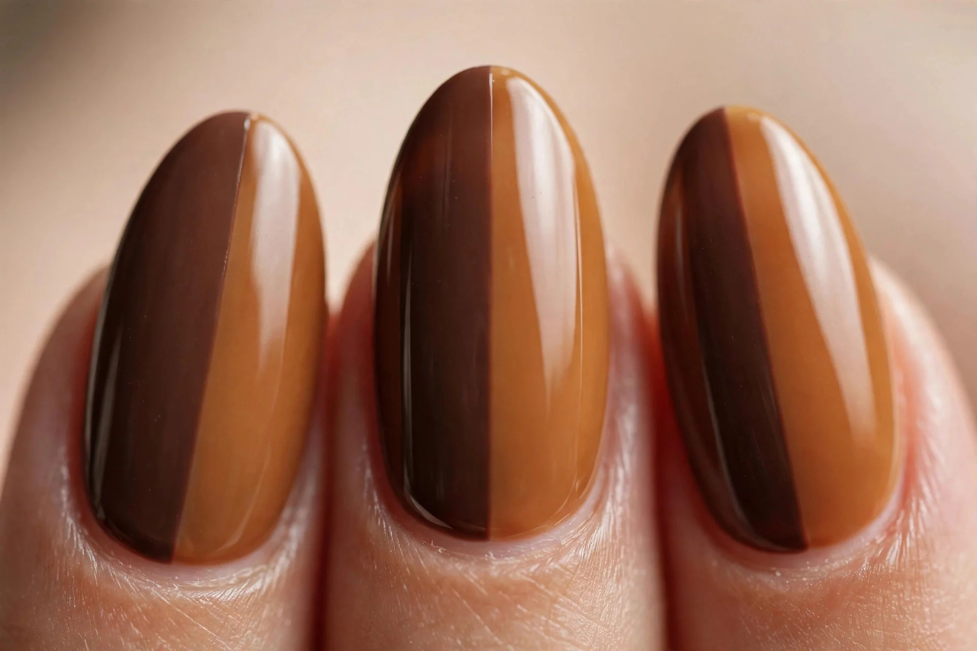 Almond nails split two-tone between deep mocha and warm caramel, crisp line, glossy, beige background
