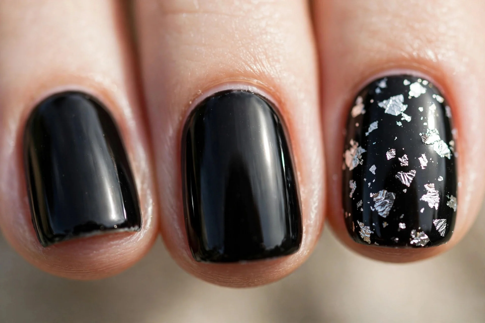 jet black nails with scattered silver foil flakes on accent nails