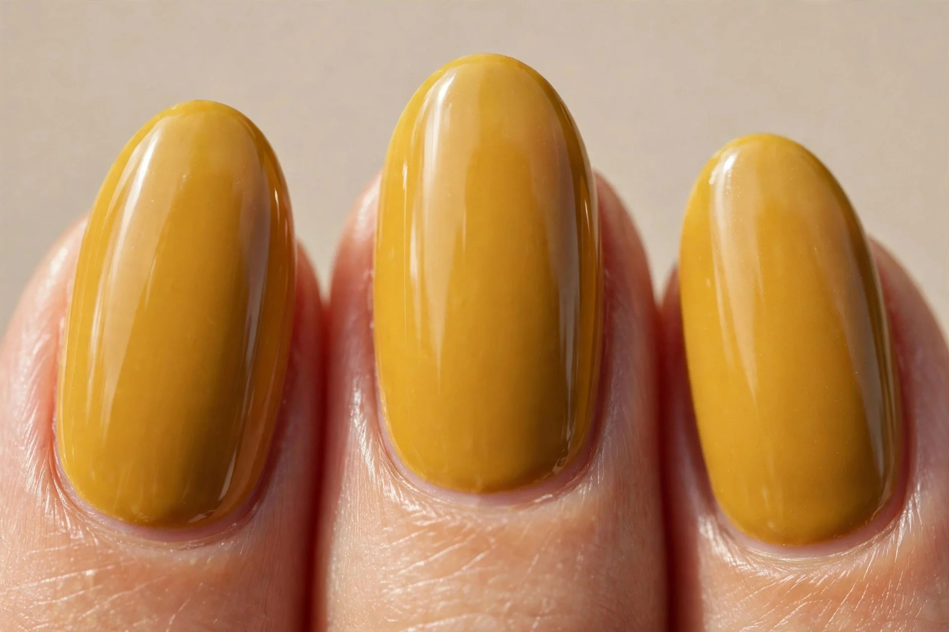 rich golden mustard crème polish, medium-length almond nails, glossy finish, no nail art