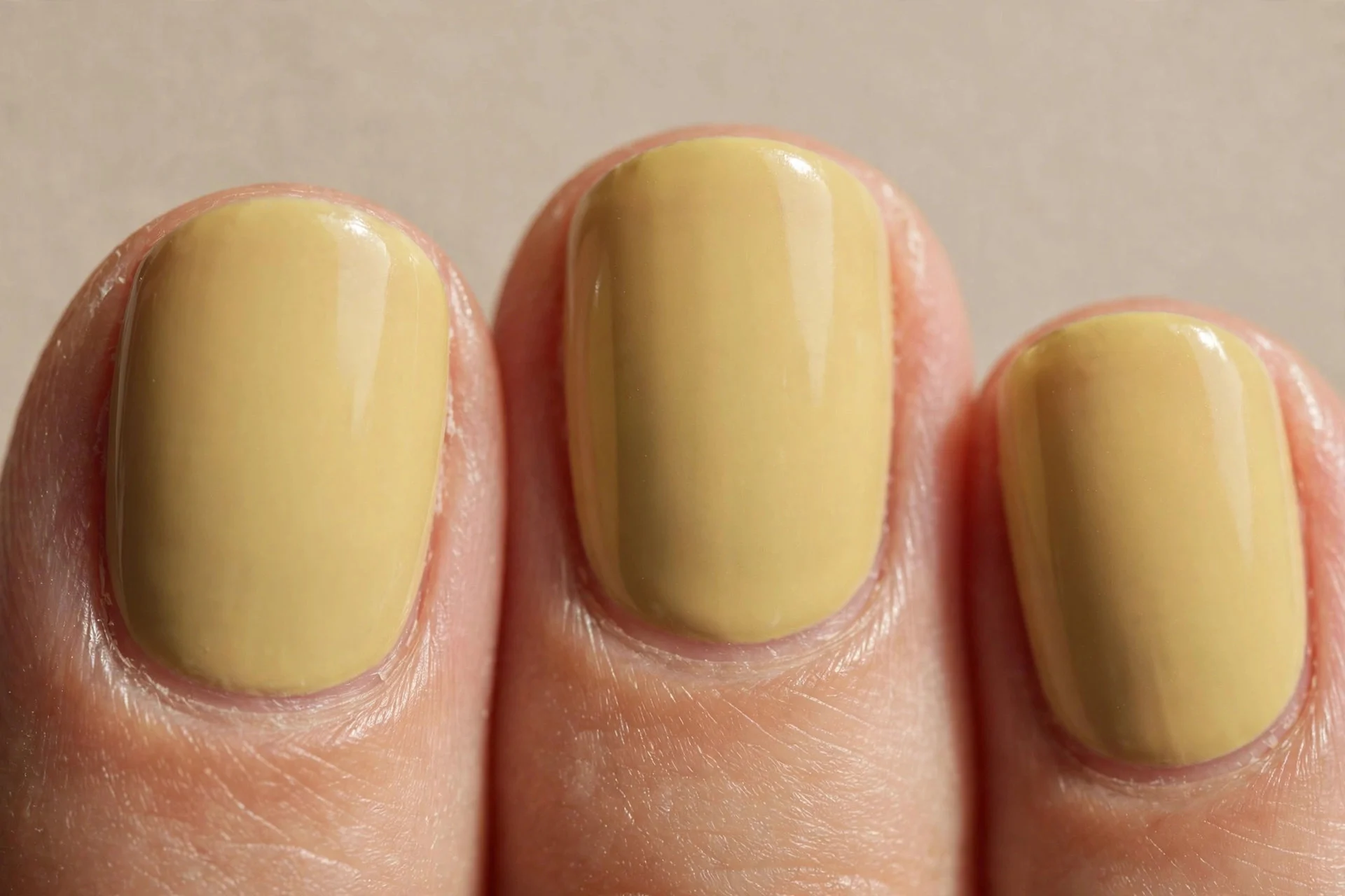 pale Dijon muted crème, short rounded nails, clean glossy finish, no nail art