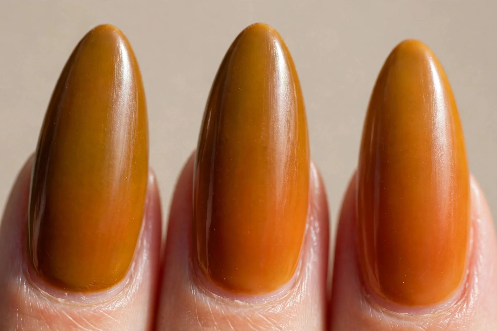 burnt mustard base fading into amber-orange gradient tips, long almond nails, glossy