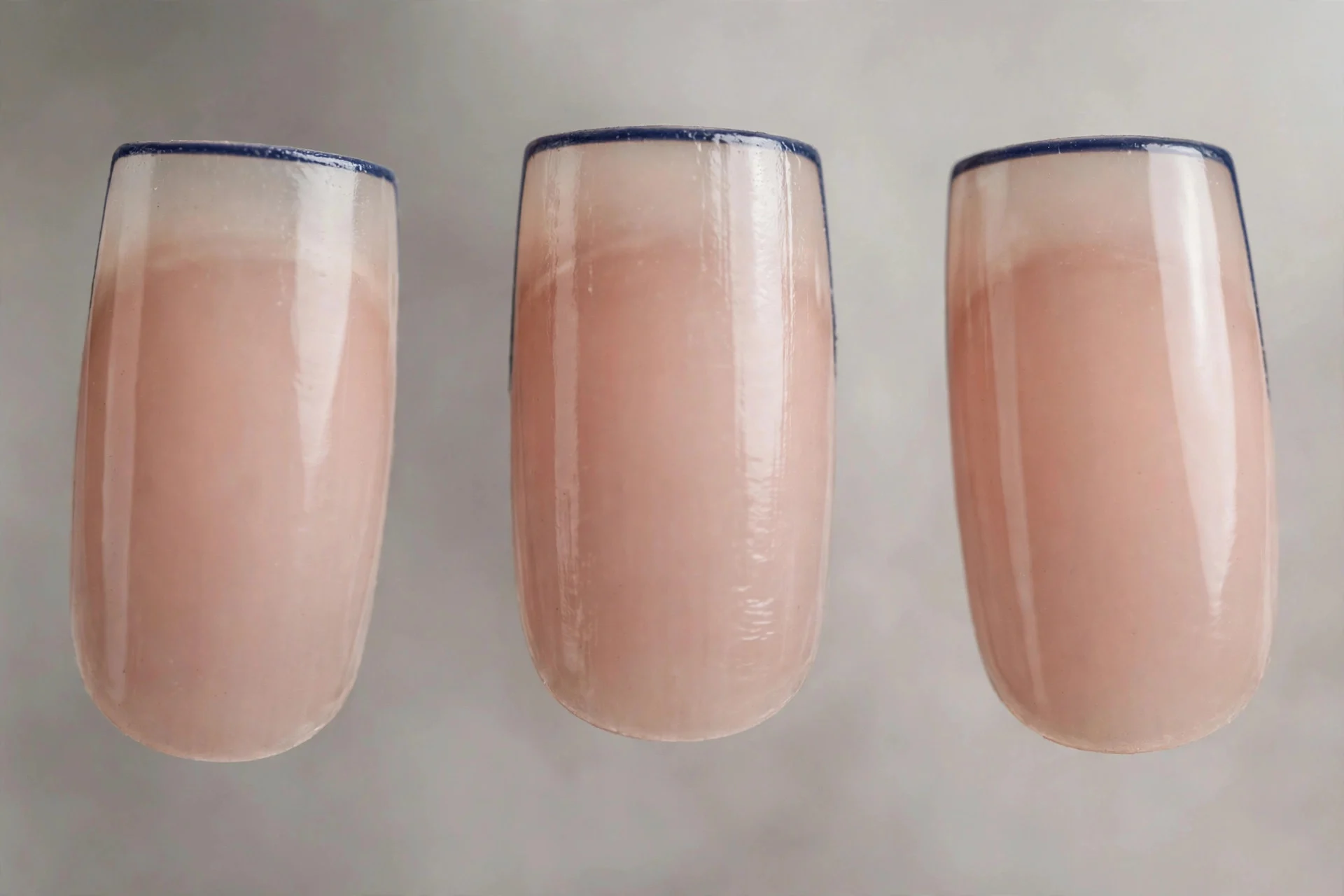 Sheer nude nails with thin navy micro French tips, square