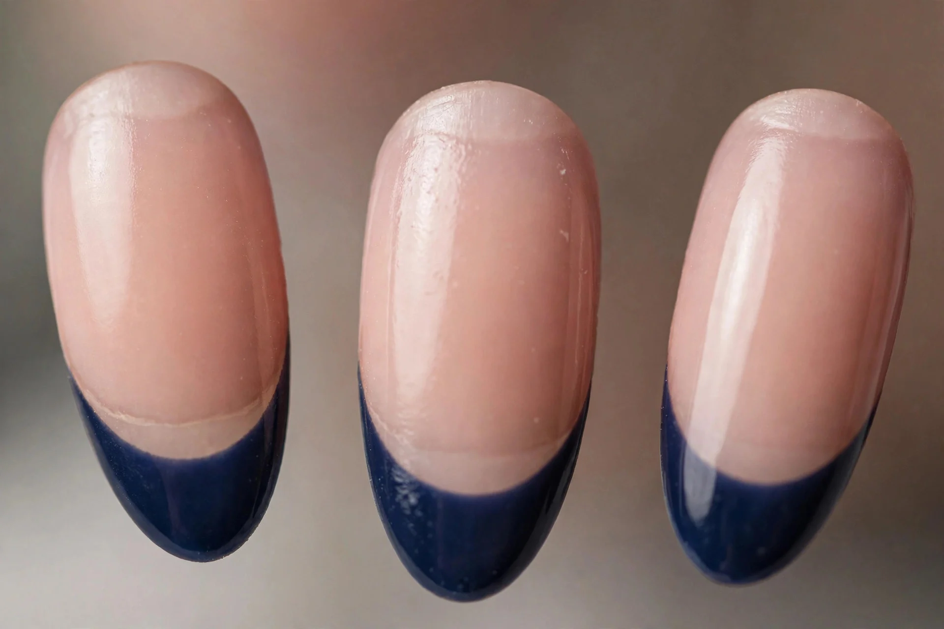 Nude base with navy tips and half-moon cuticle detail, almond