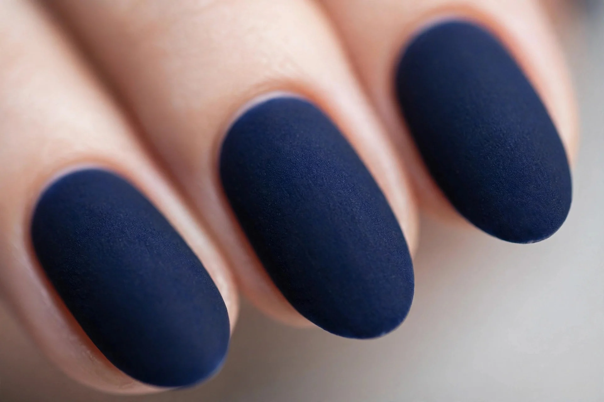 Navy polish with velvet matte finish, medium almond nails