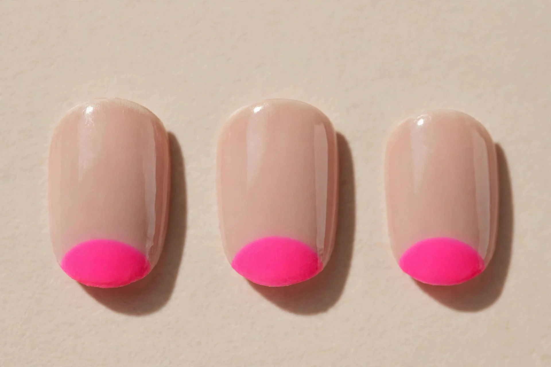 neon pink half-moons, nude short rounded nails