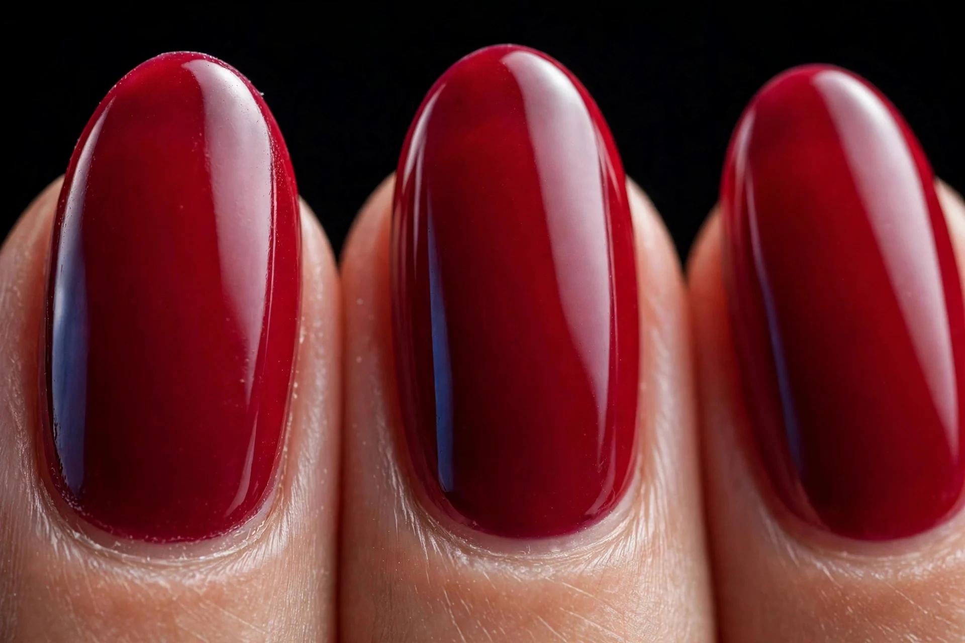 Almond nails in glossy classic blue-red gel, black background