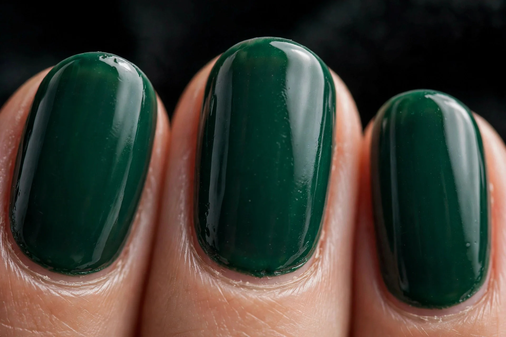 Oval nails in deep emerald green cr&egrave;me gel, dark background