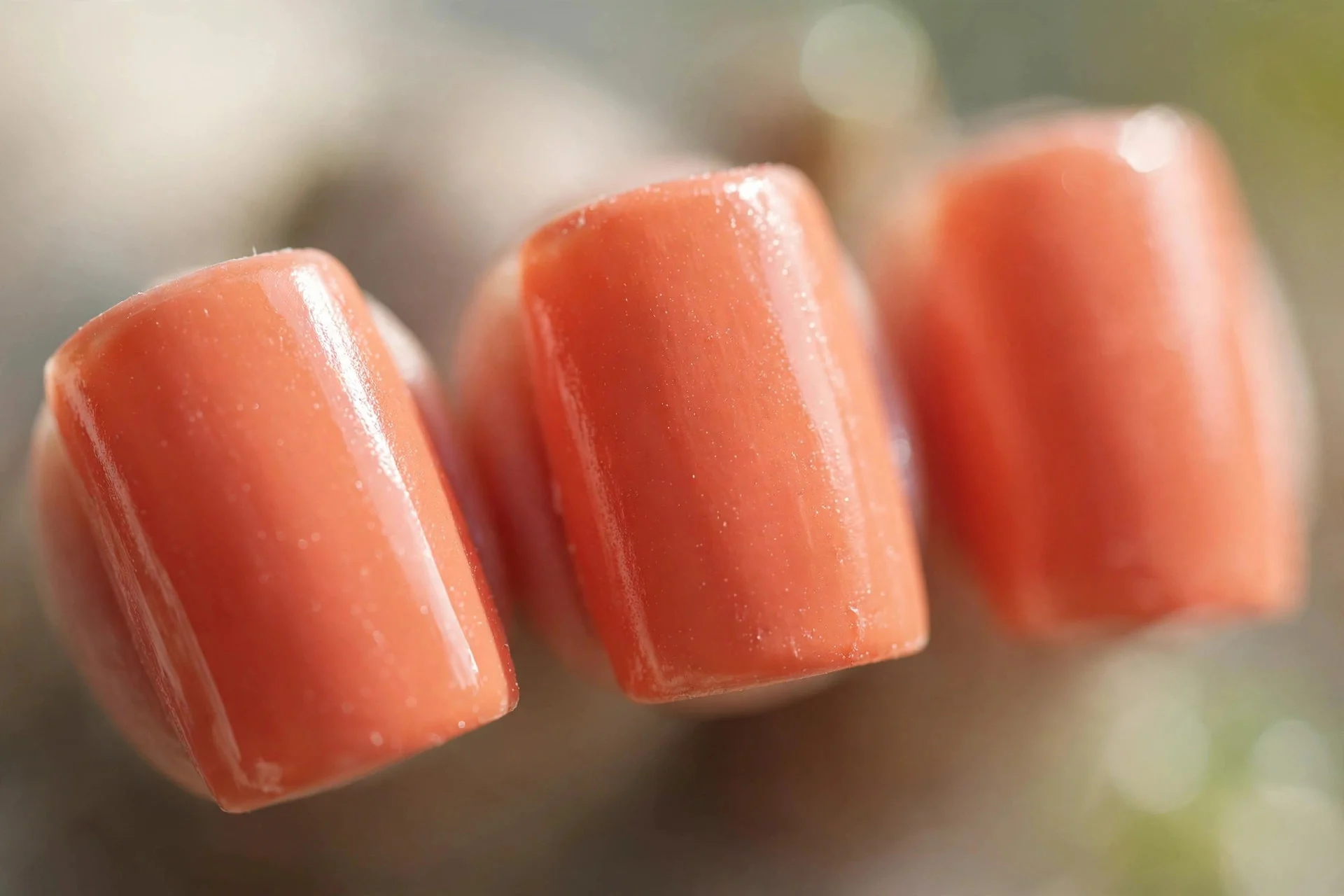 Soft coral orange polish, short square nails, glossy finish