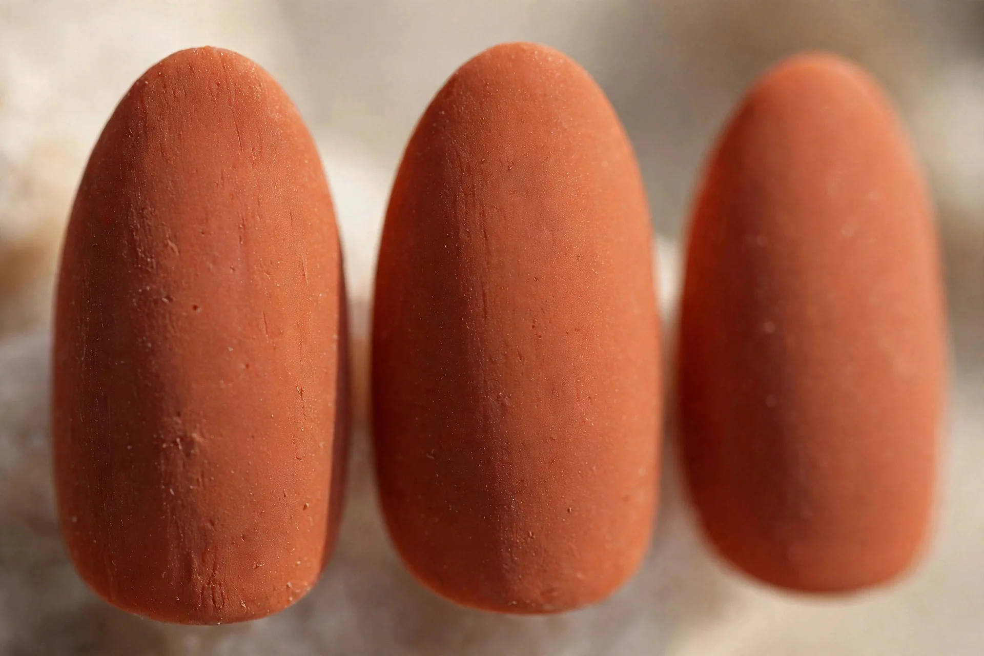 Muted terracotta orange polish, almond nails, matte finish