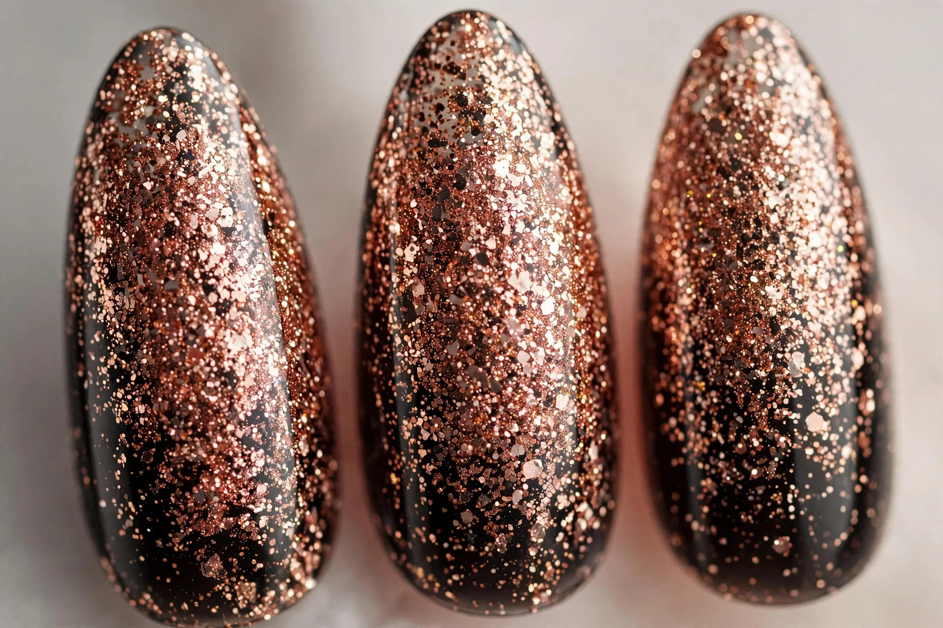 Black jelly nails with dense rose gold glitter, long almond nails