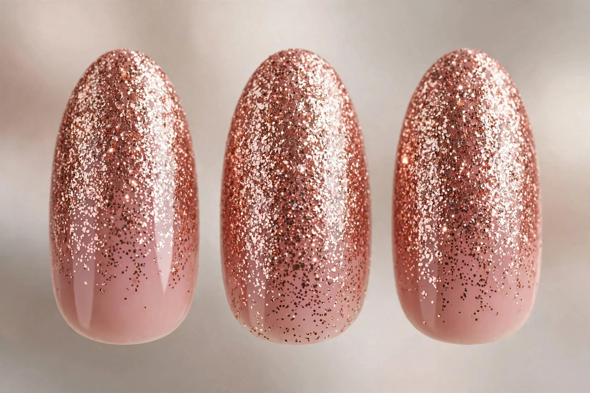 Dense rose gold glitter nails over pink nude base, medium almond
