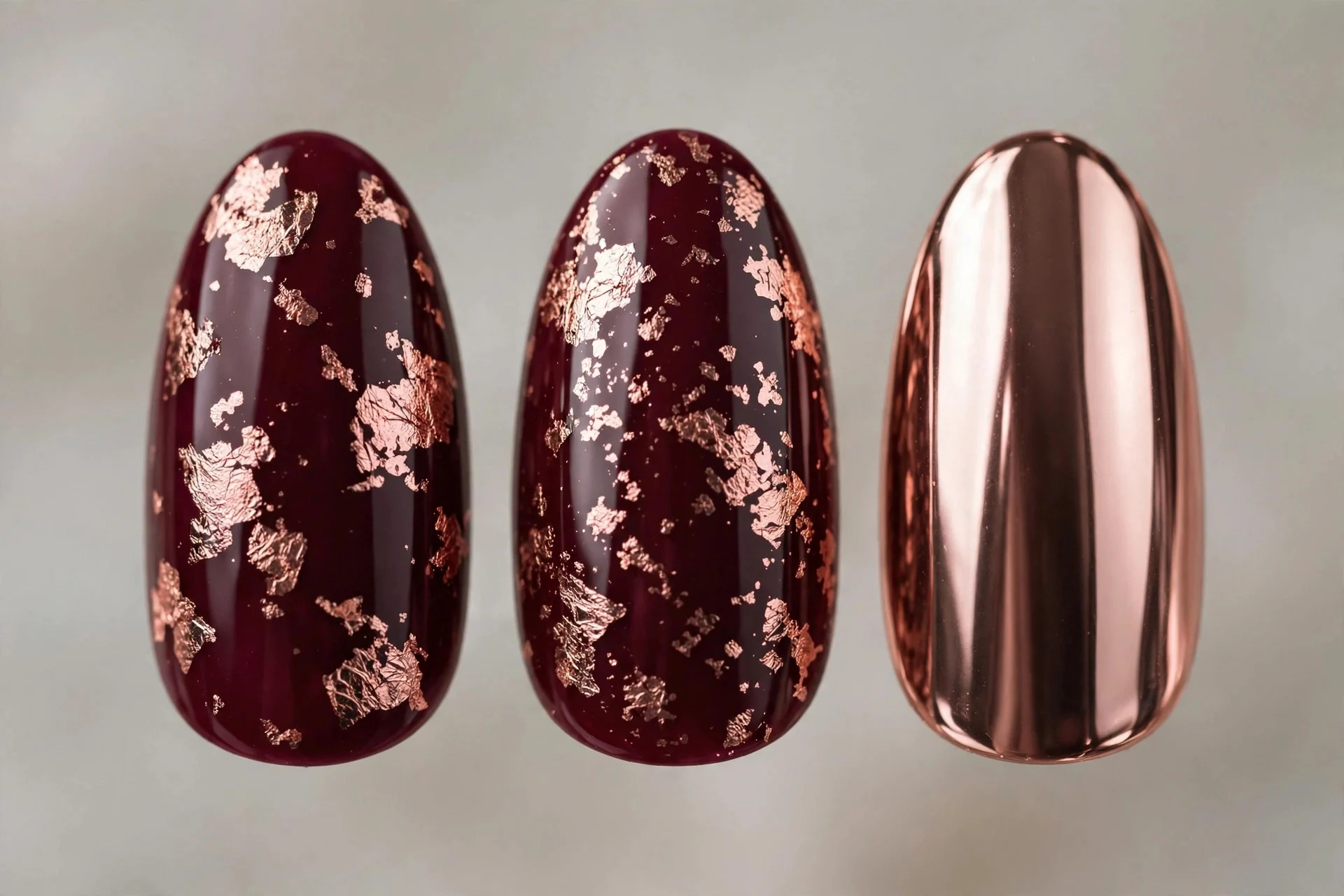 Deep burgundy nails with rose gold foil and chrome accent nail, almond