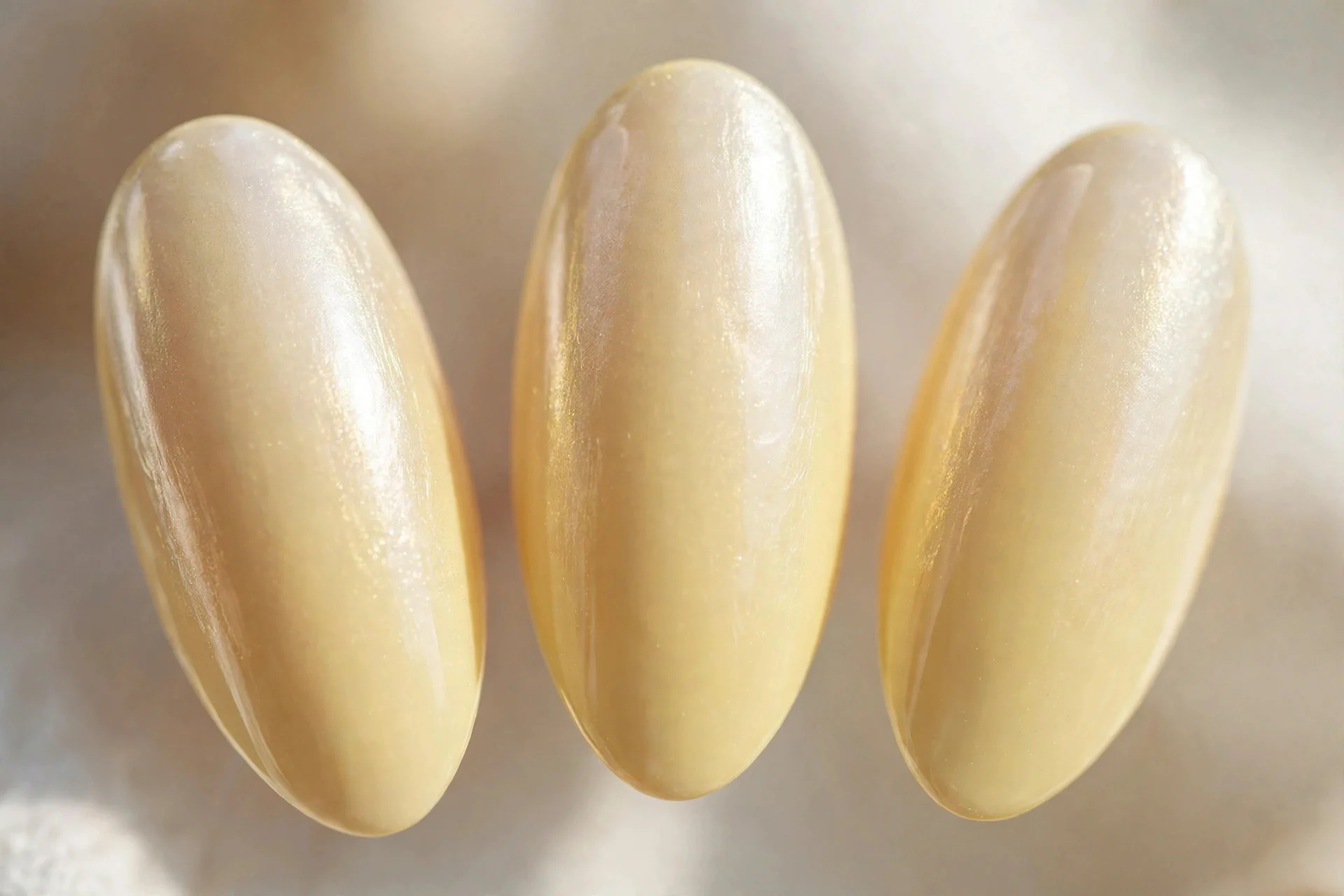Butter yellow nails with sheer chrome glaze, almond