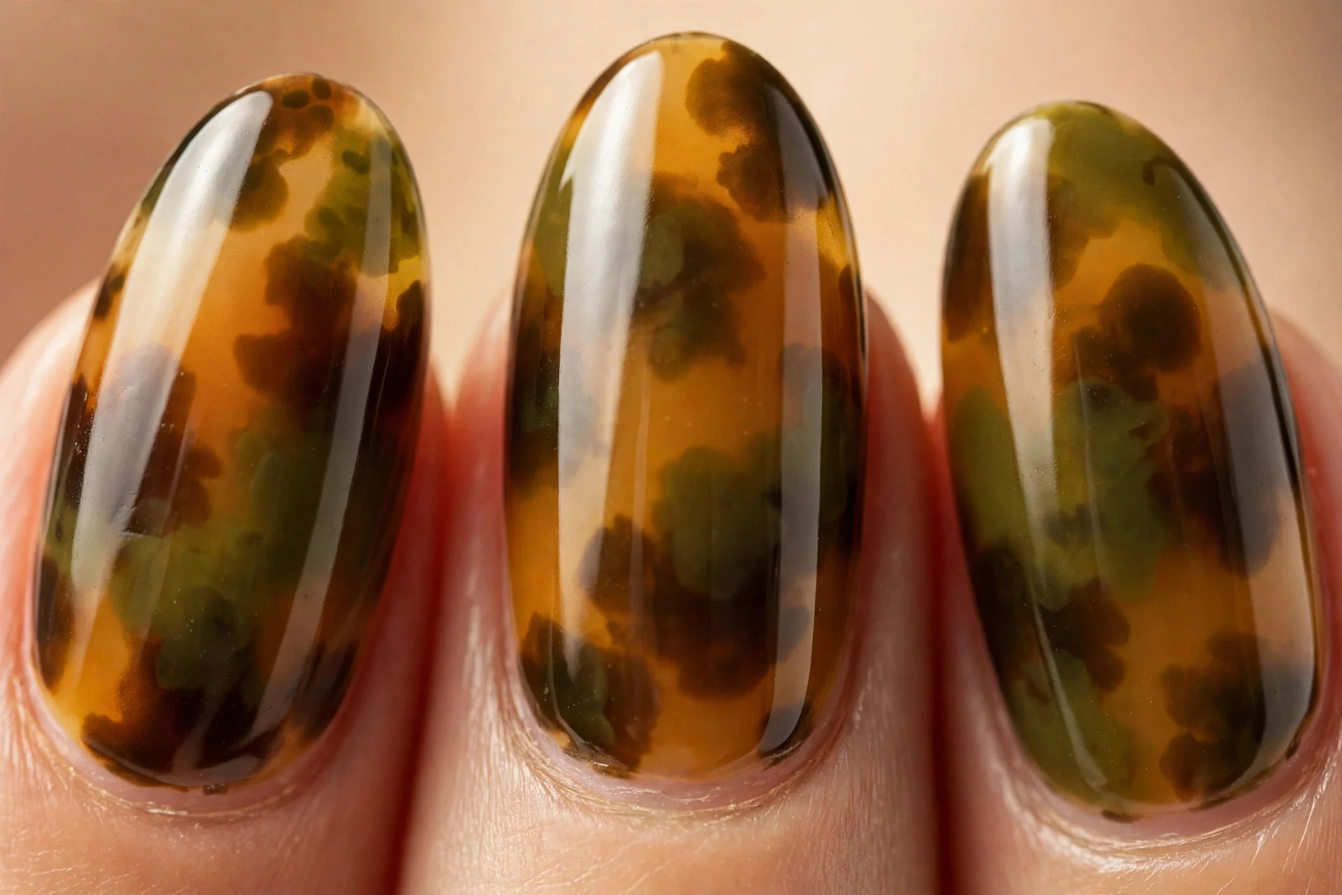 Almond nails with olive and amber tortoiseshell pattern, glossy, warm background