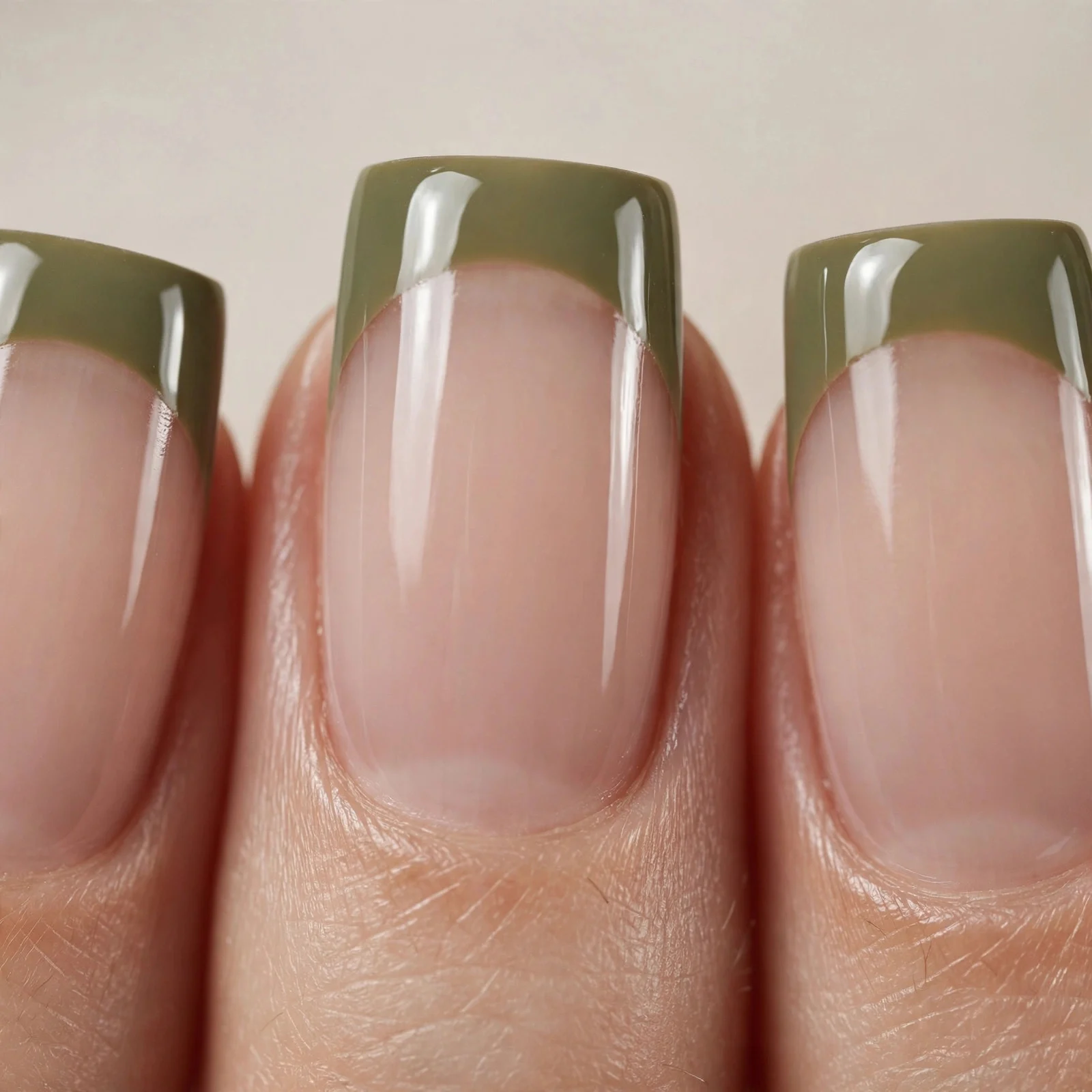 Square nails with olive green French tips on sheer nude, glossy, neutral background