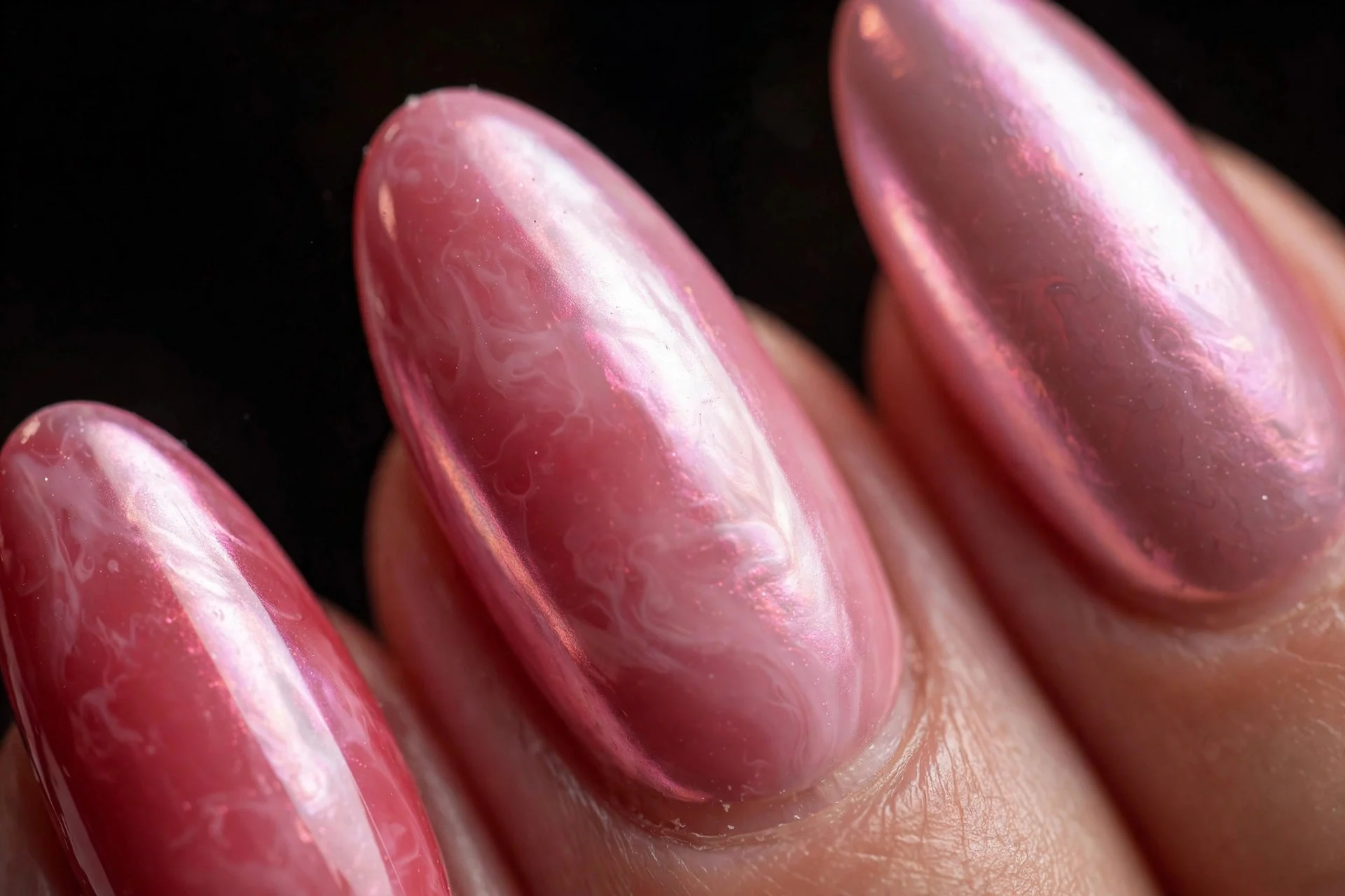 Almond nails with deep strawberry milk under pink pearl chrome, luminous finish, dark background