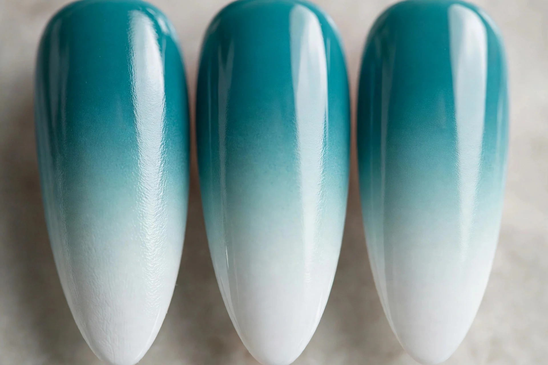 Teal to white ombr&eacute; gradient, long almond nails