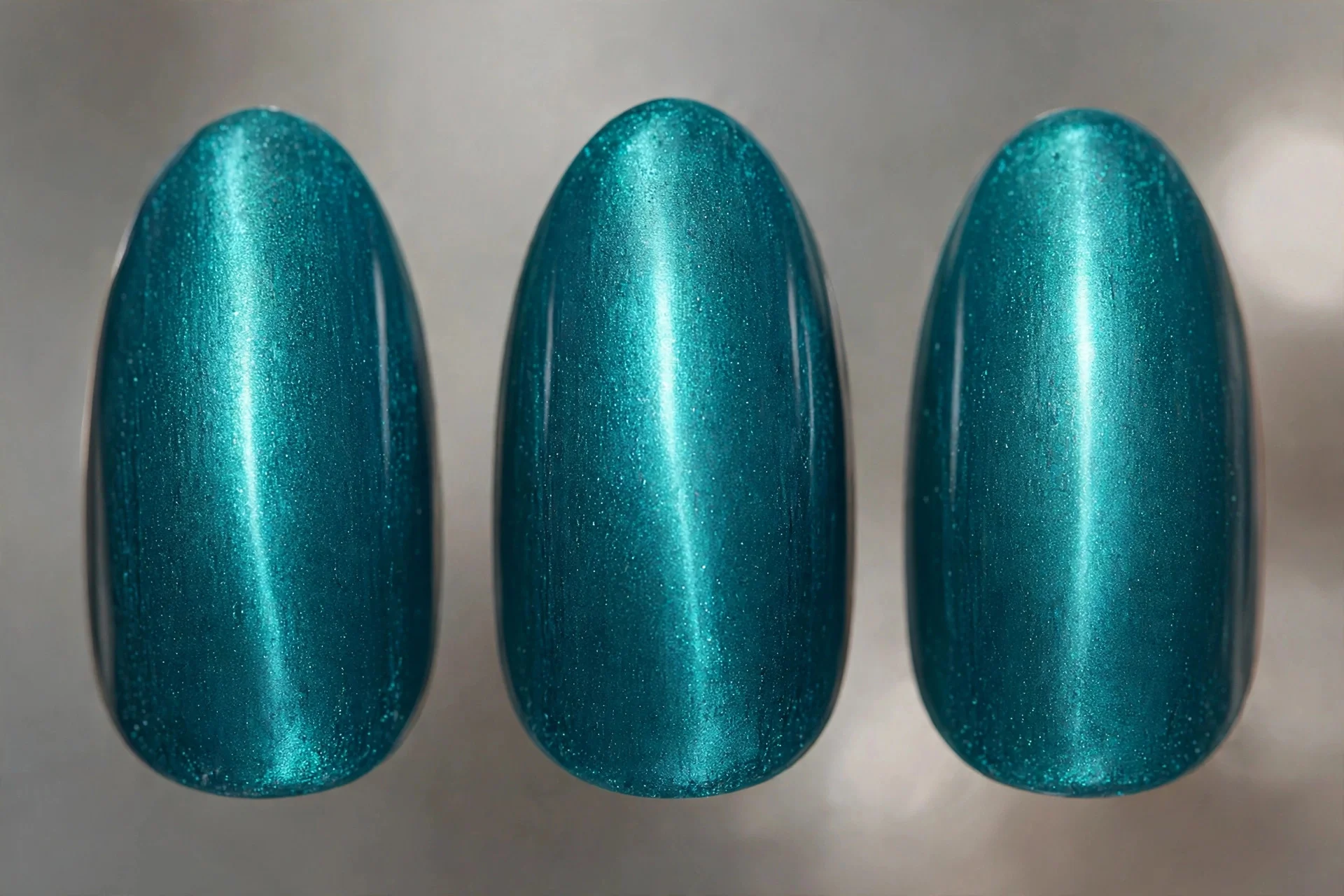 Teal magnetic cat-eye nails with glowing centre line, almond