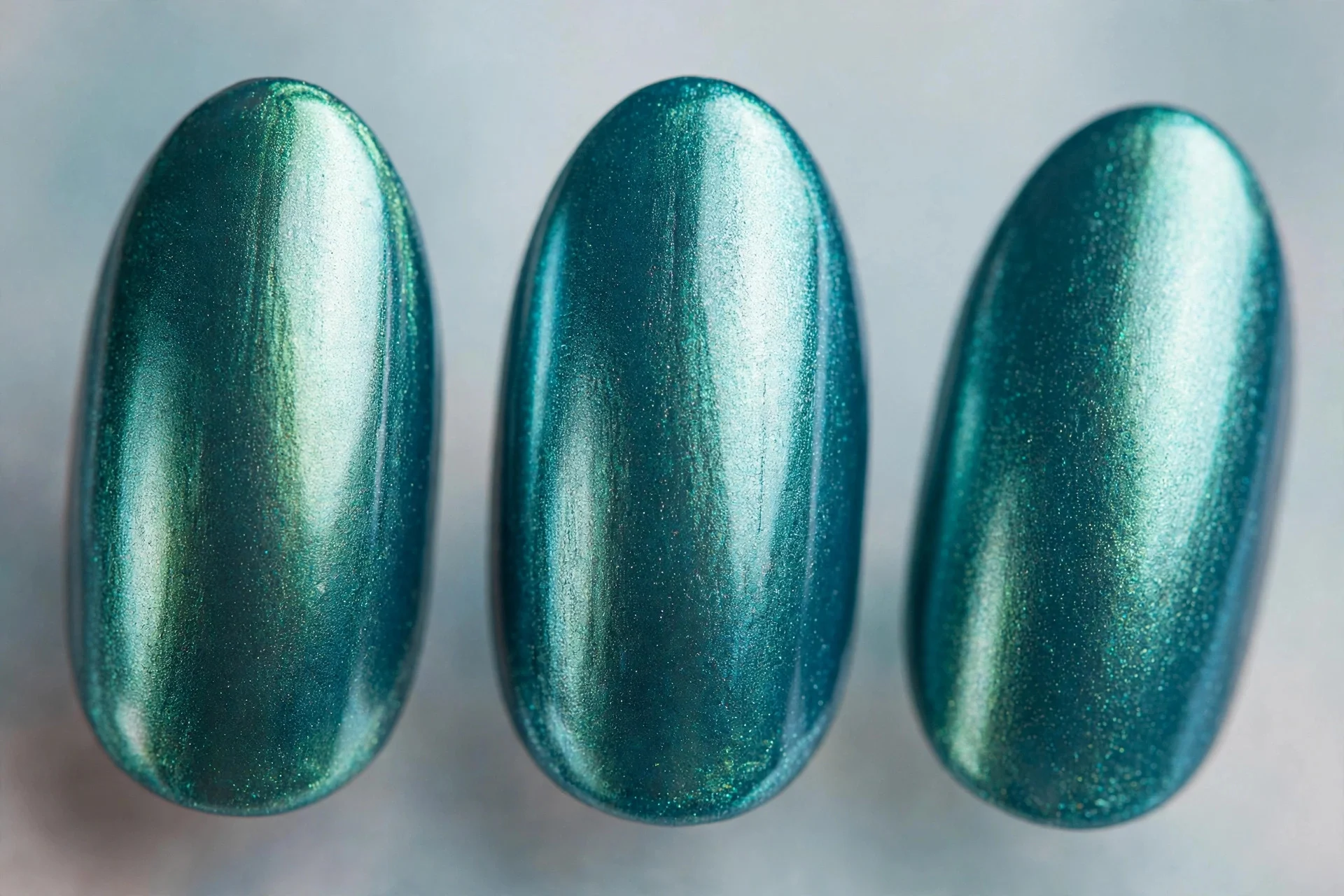 Teal polish with chrome powder finish, almond nails, metallic