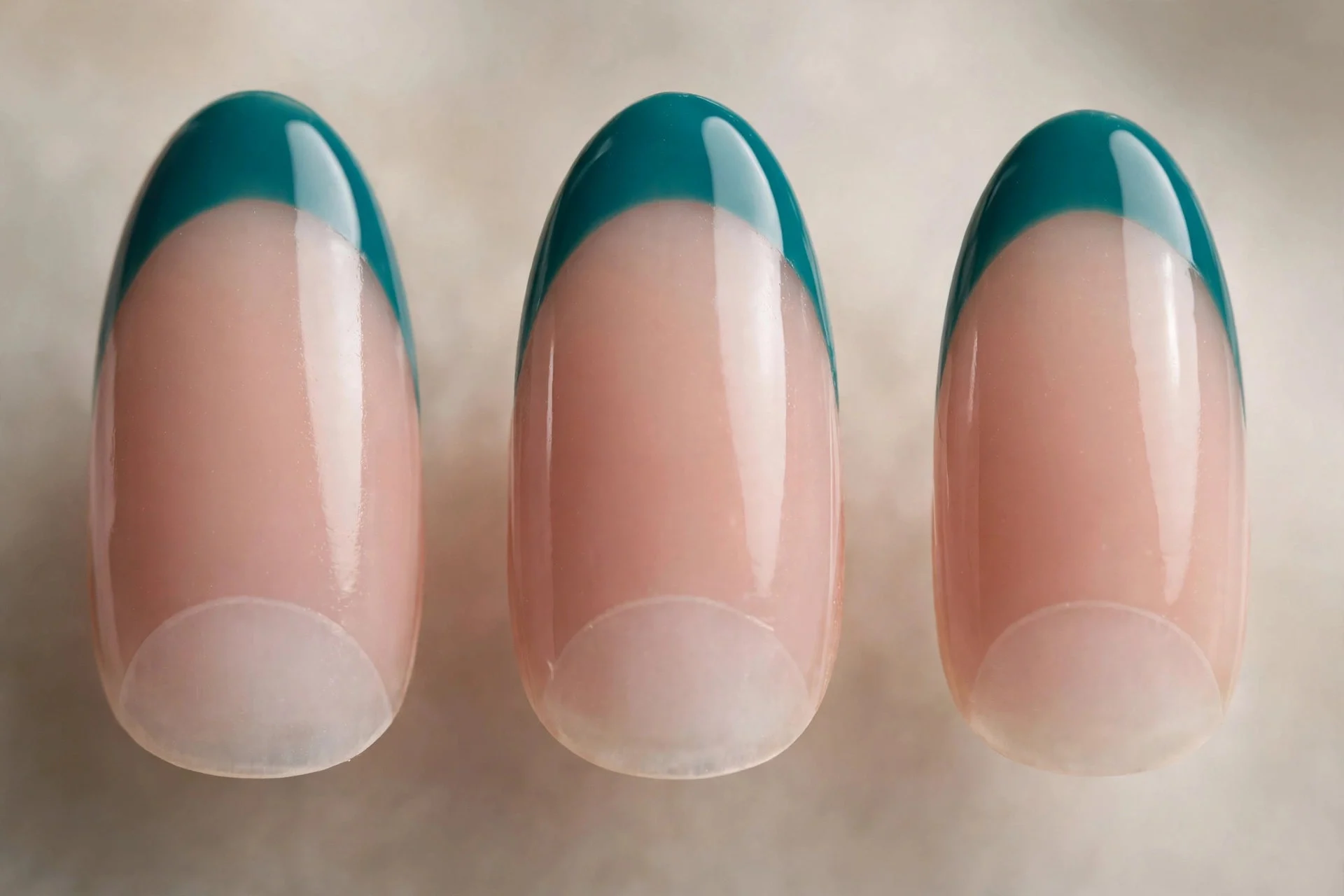 Sheer nude base with teal tips and half-moon cuticle, almond