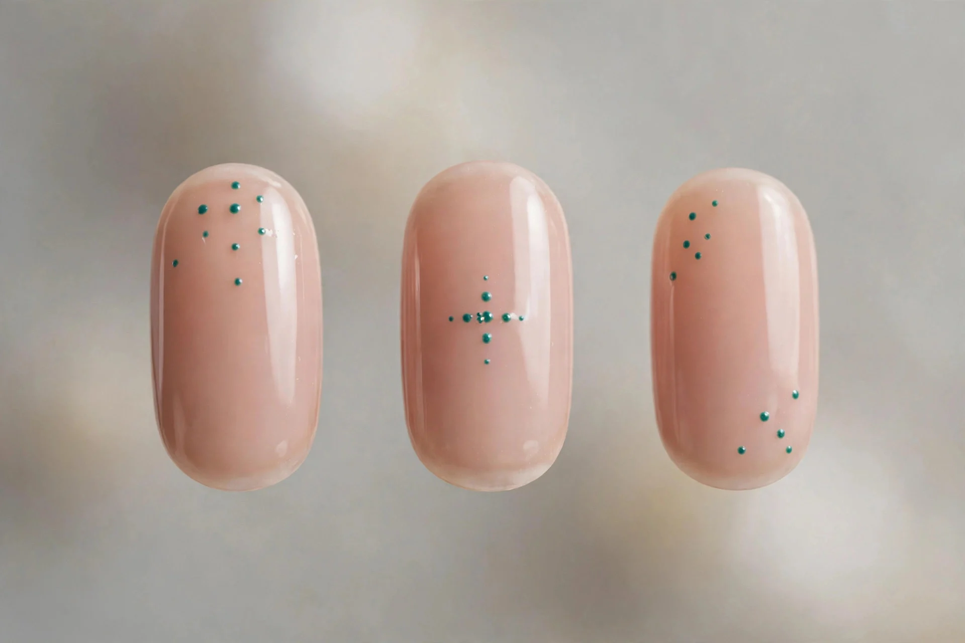 Sheer nude nails with small teal dot art, short oval