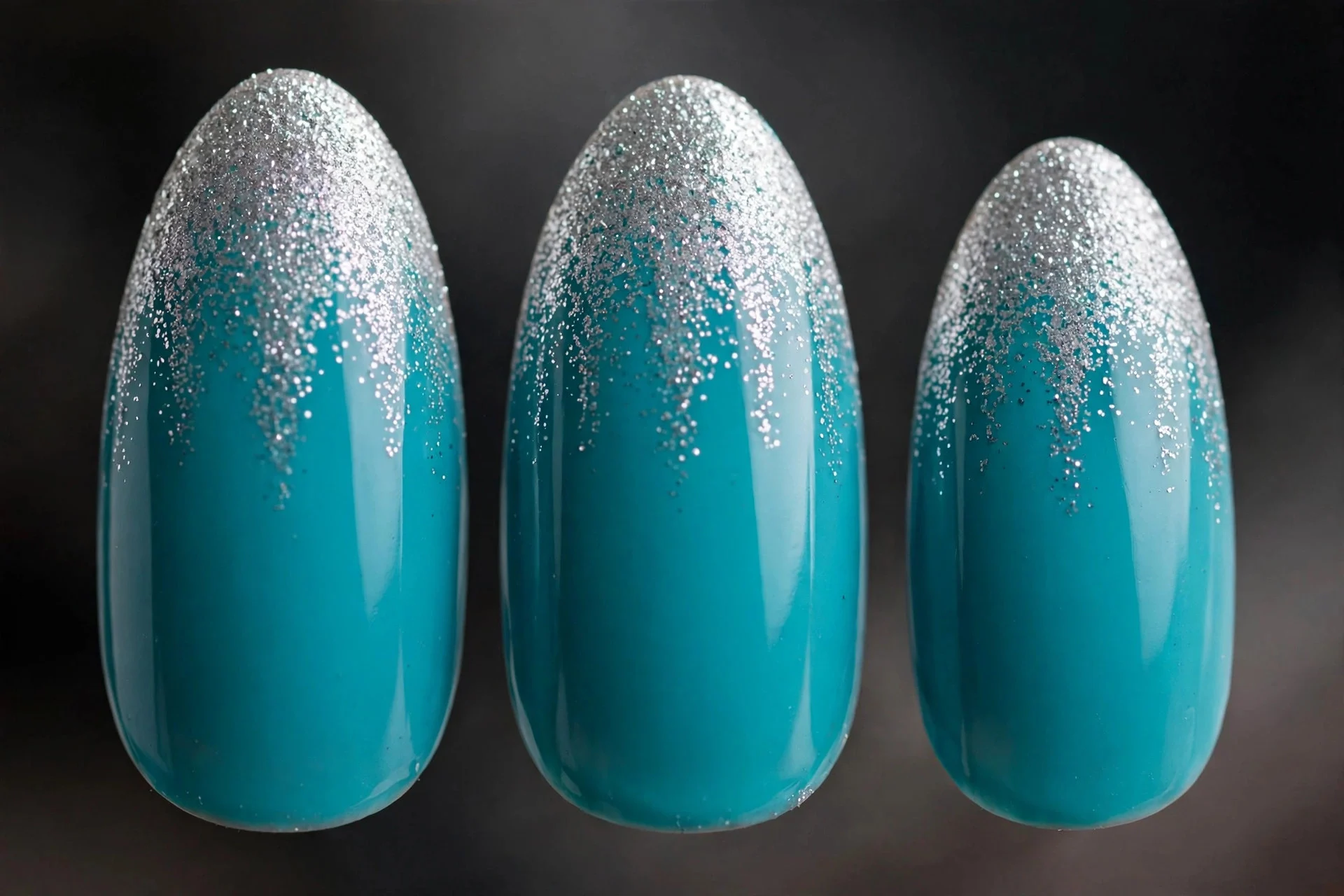 Turquoise nails with silver glitter sponged at tips, almond