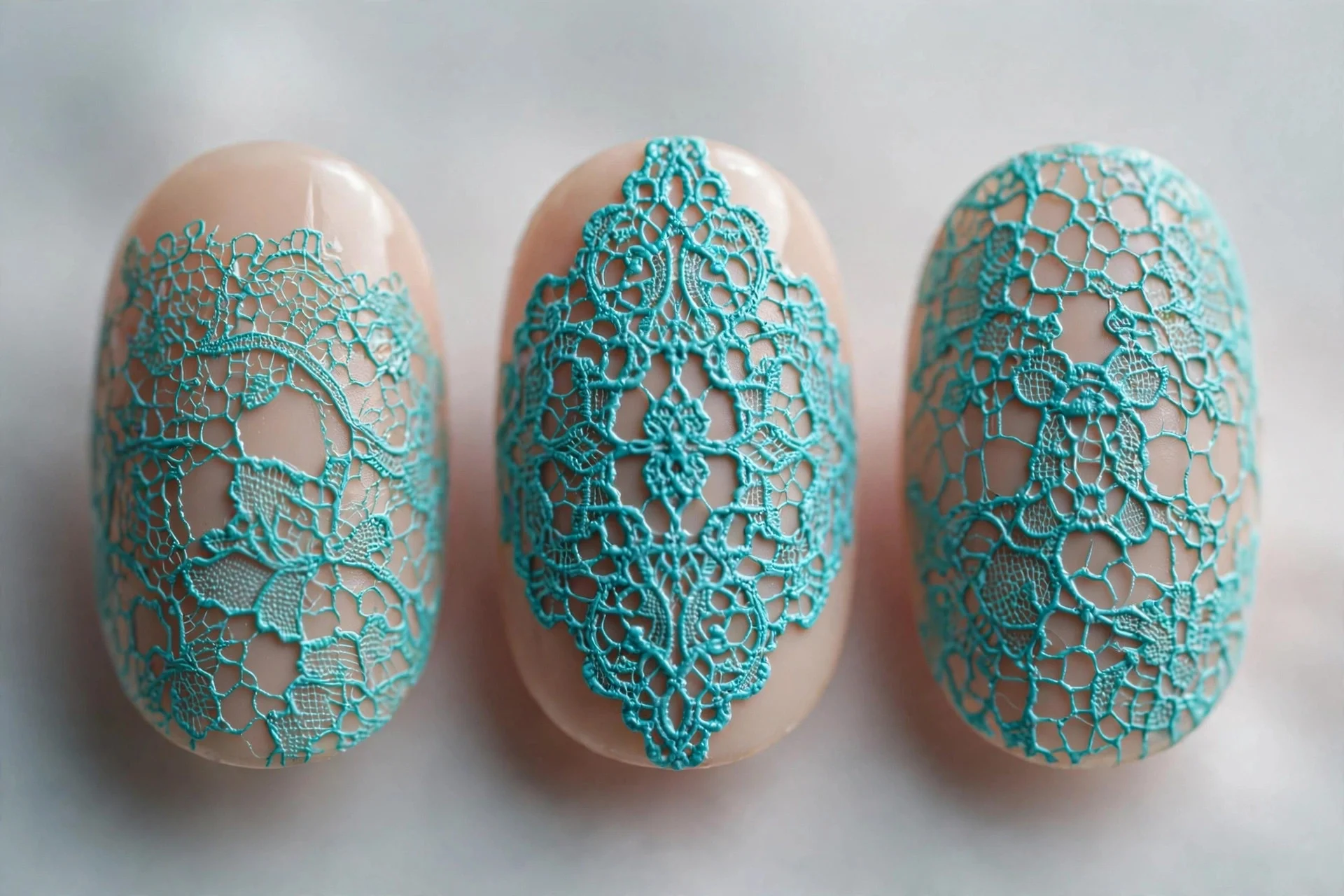 Nude nails with stamped turquoise lace pattern, oval
