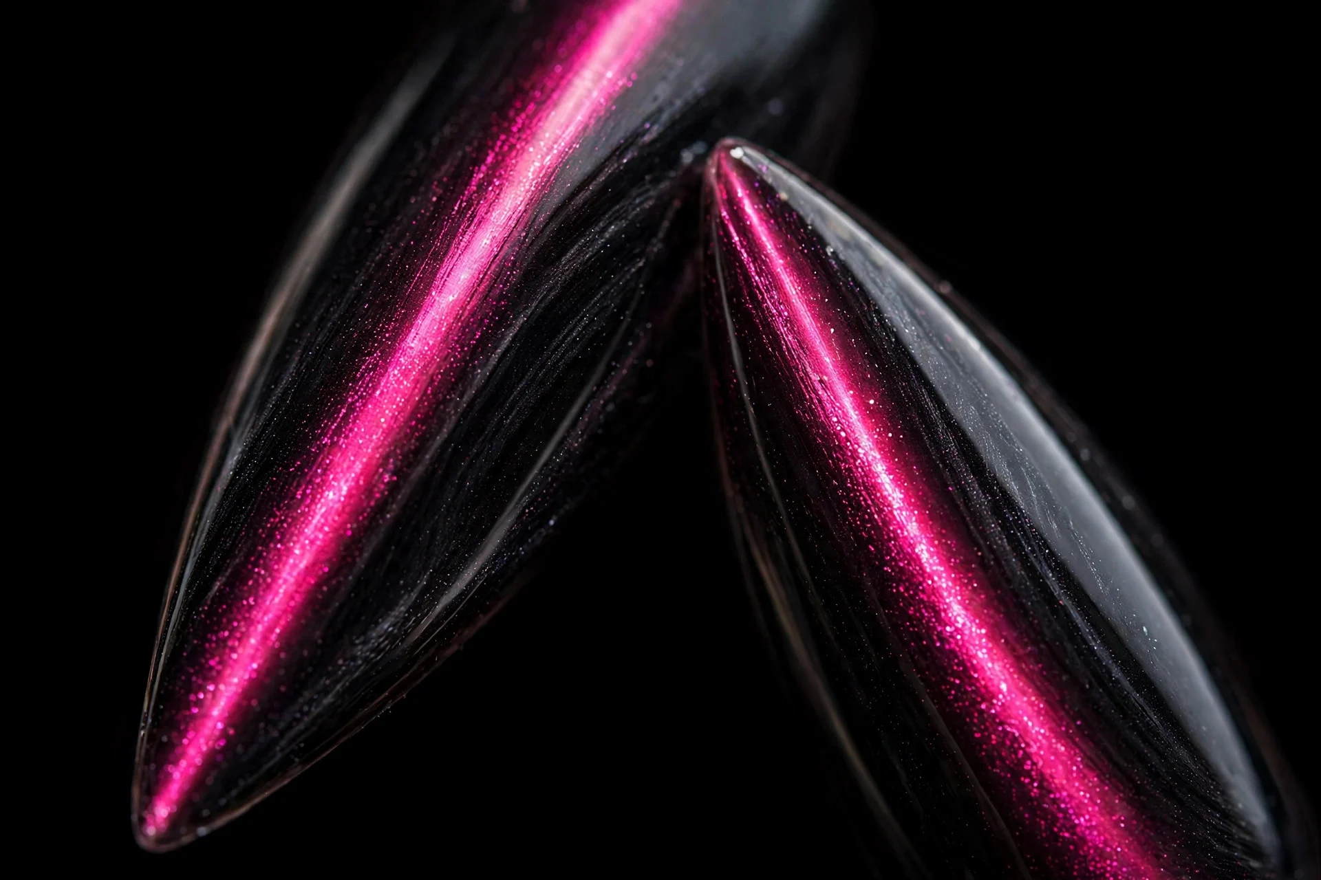 Extreme macro of two stiletto fingernails, black cat-eye gel, neon hot pink band, glossy, dark background