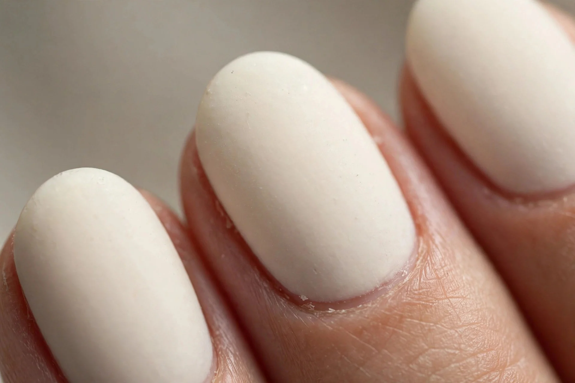 Oval nails in vanilla creme with soft satin matte finish, neutral background