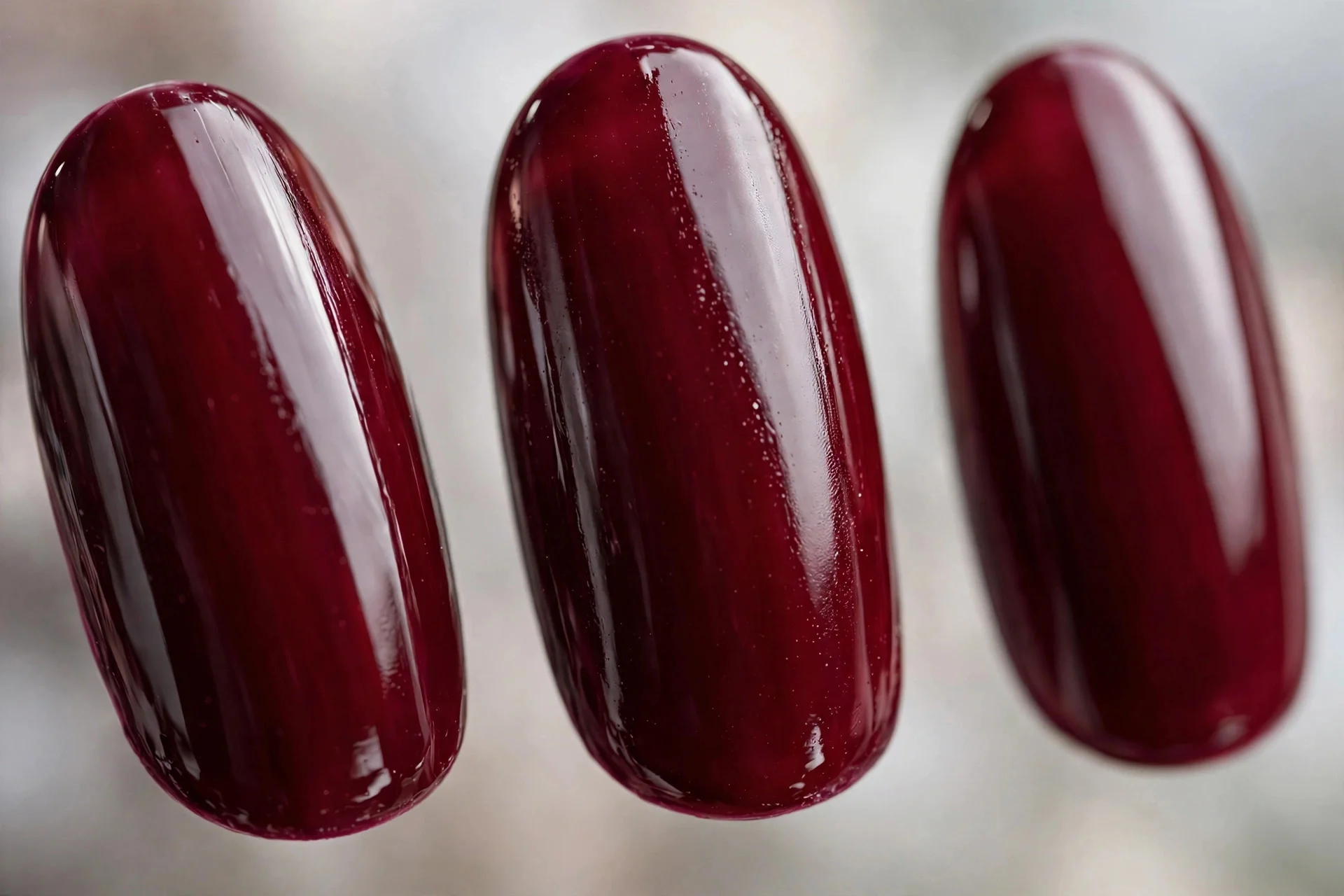 Deep merlot wine-red polish, medium almond nails, high gloss shine