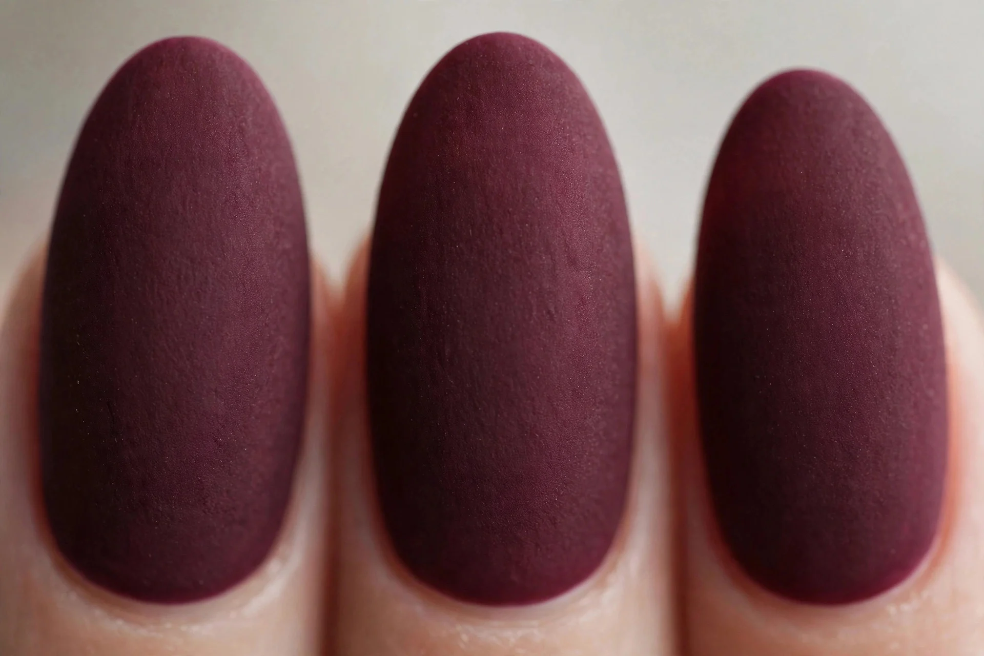 Merlot wine polish with soft matte finish, medium almond nails